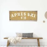 a wooden bench with a gray and white throw pillow, and a framed sign with the word "APRESS" on it.