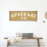 a wooden bench with a gray and white throw pillow, and a framed sign with the word "APRESS" on it.