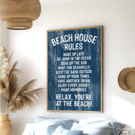 The Beach House Rules Sign, a blue painted wood nautical piece, hangs on the wall listing relaxing activities, adding cozy beach house decor to any room.