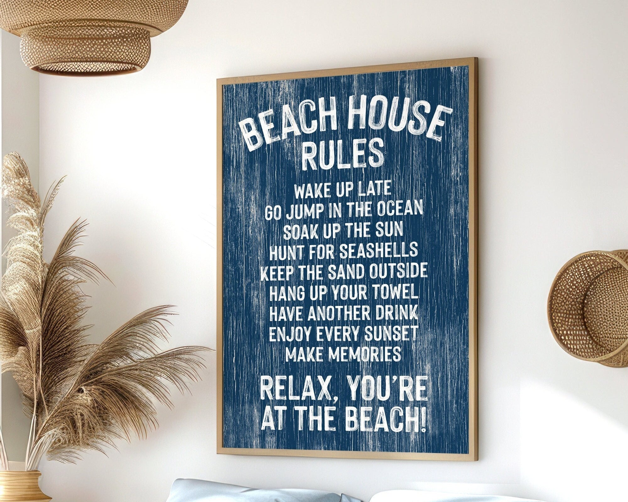 The Beach House Rules Sign, a blue painted wood nautical piece, hangs on the wall listing relaxing activities, adding cozy beach house decor to any room.