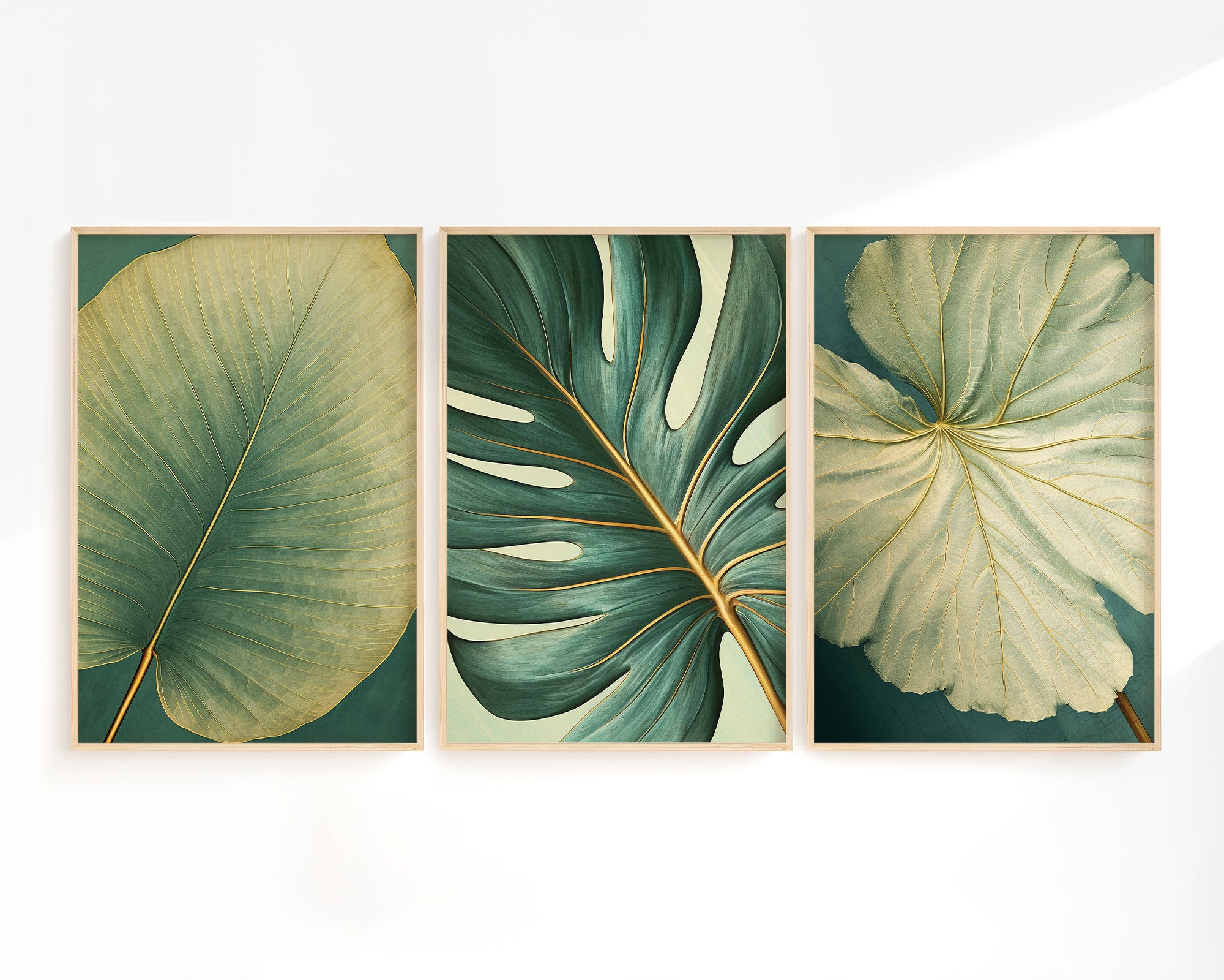 three framed prints of large, vibrant leaves in various shades of green, arranged in a row on a white wall.