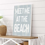 a wooden sign that says meet me at the beach