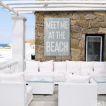 a white couch sitting on top of a patio next to a stone wall