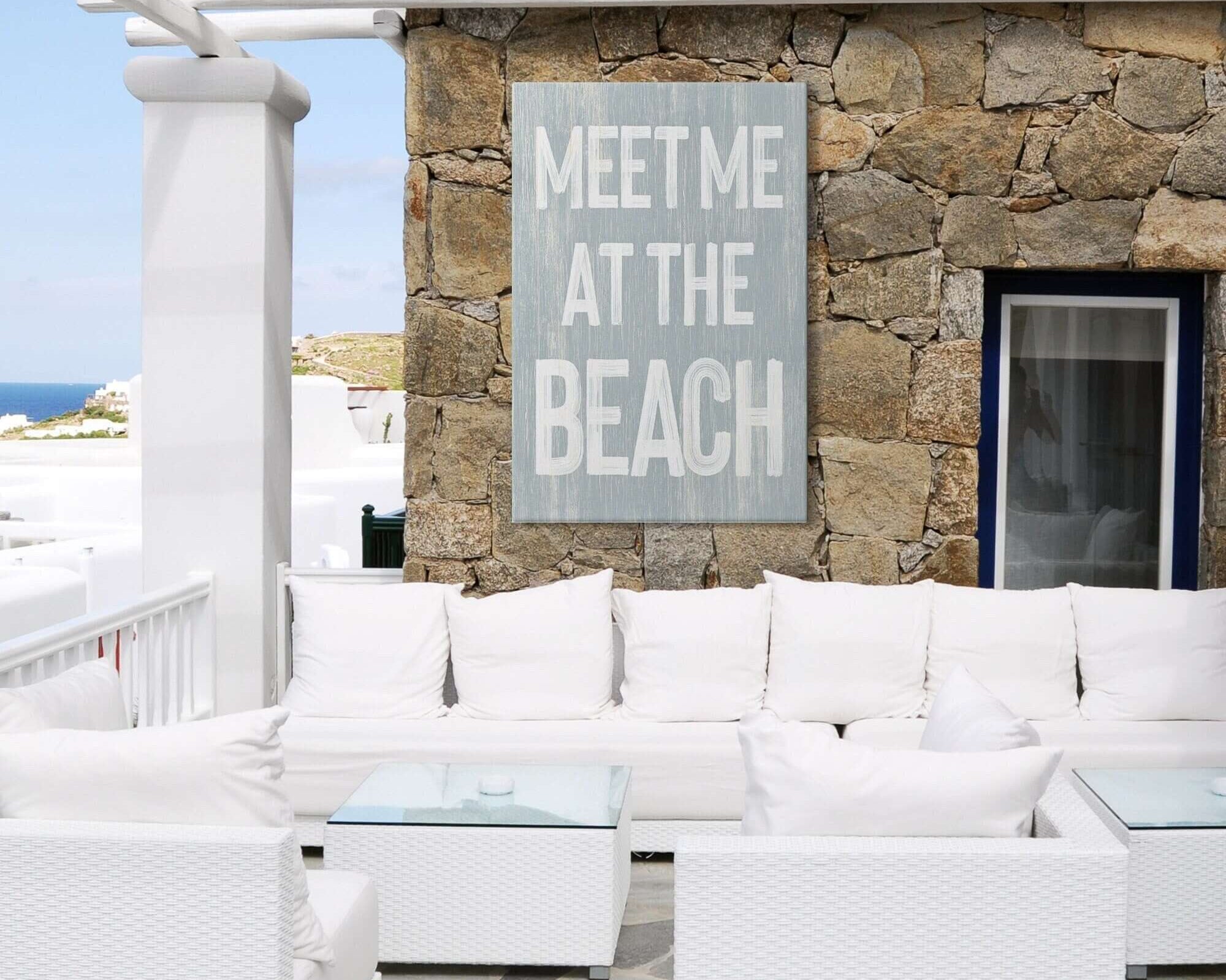 a white couch sitting on top of a patio next to a stone wall