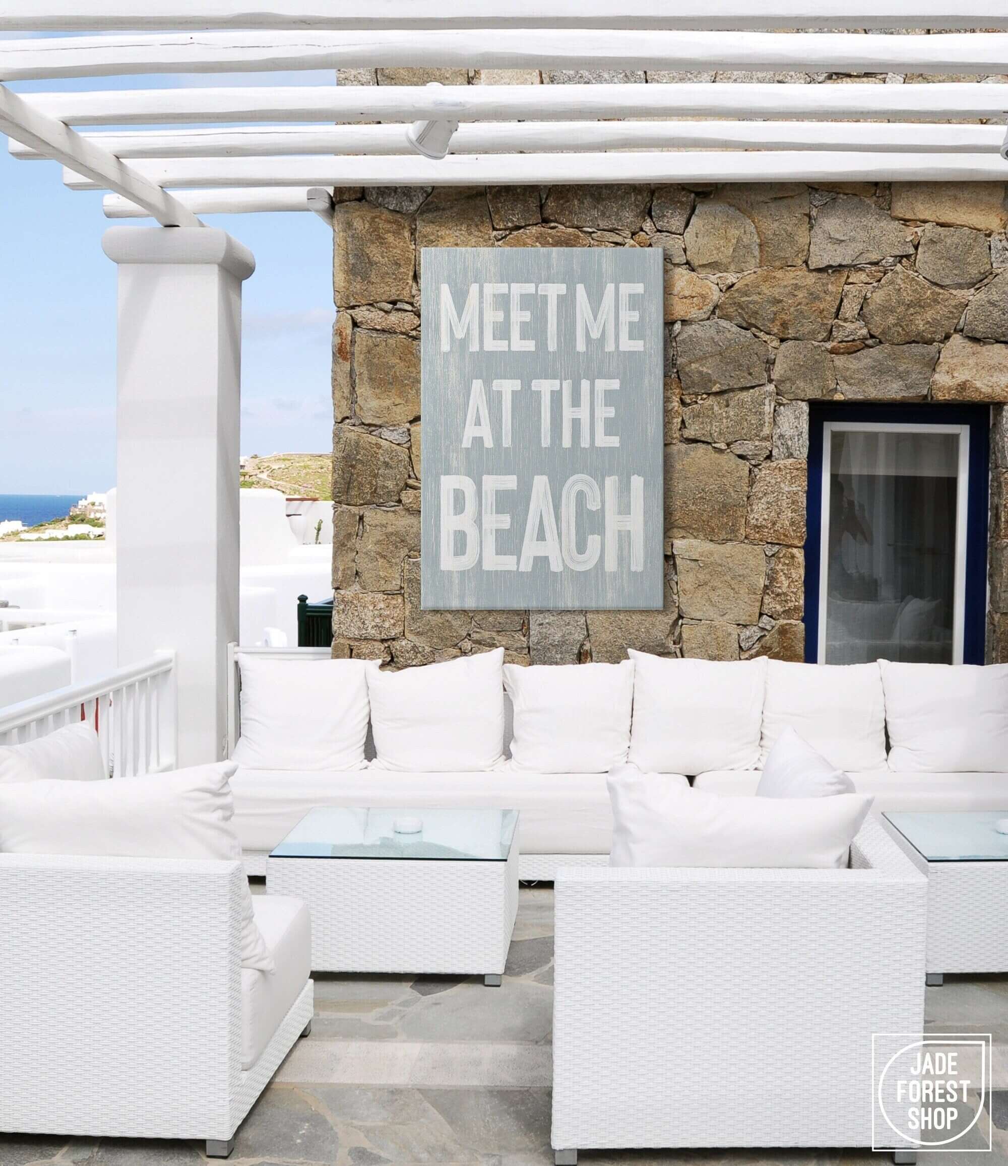 a white couch sitting on top of a patio next to a stone wall