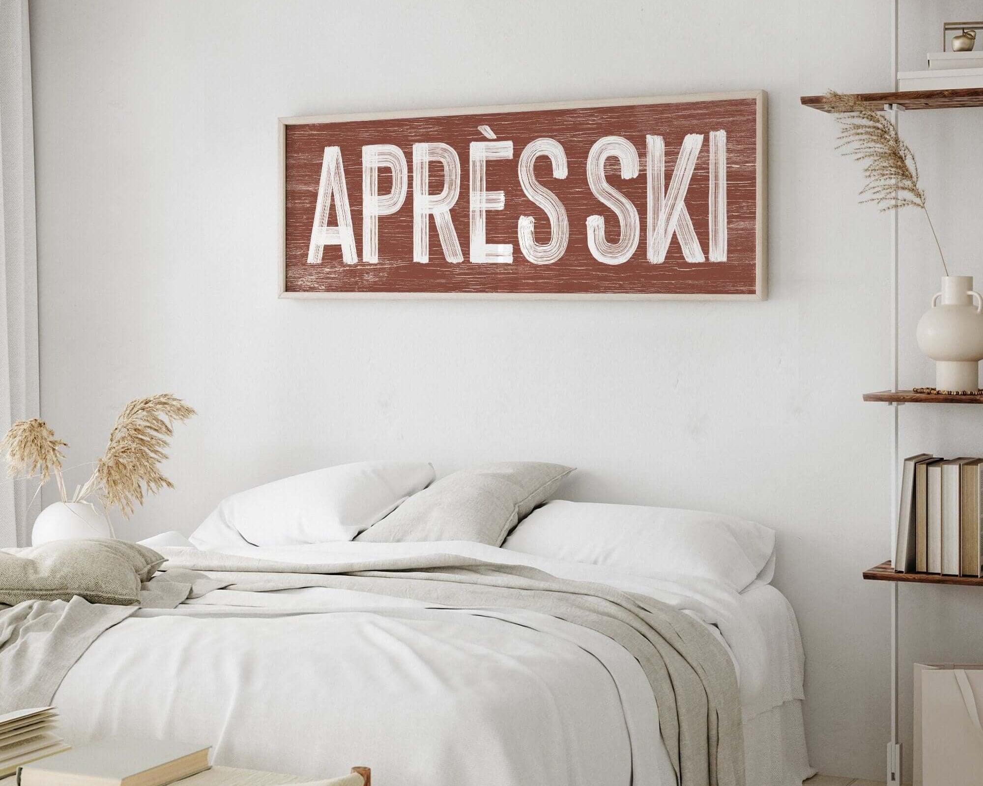 Framed Brown and white apres ski sign above a bed