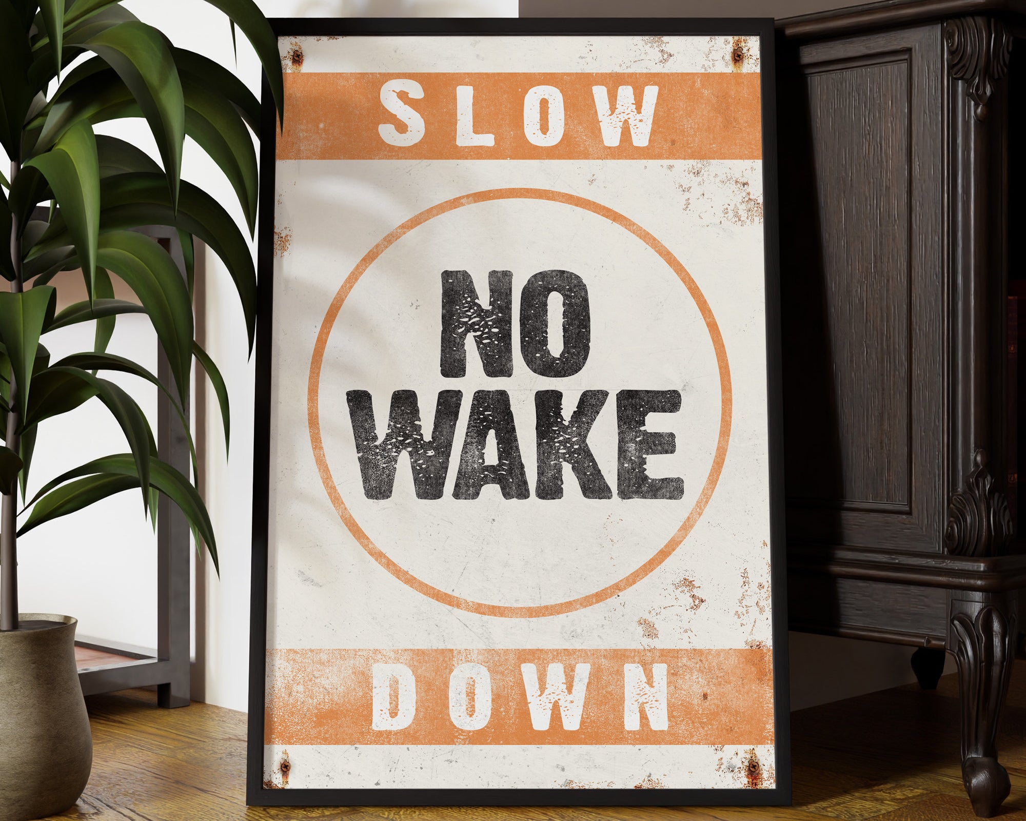 The No Wake Sign, Orange on White, adds relaxed style to your lake house—its bold retro lettering makes perfect wall decor, leaning near a plant for a laid-back vibe.
