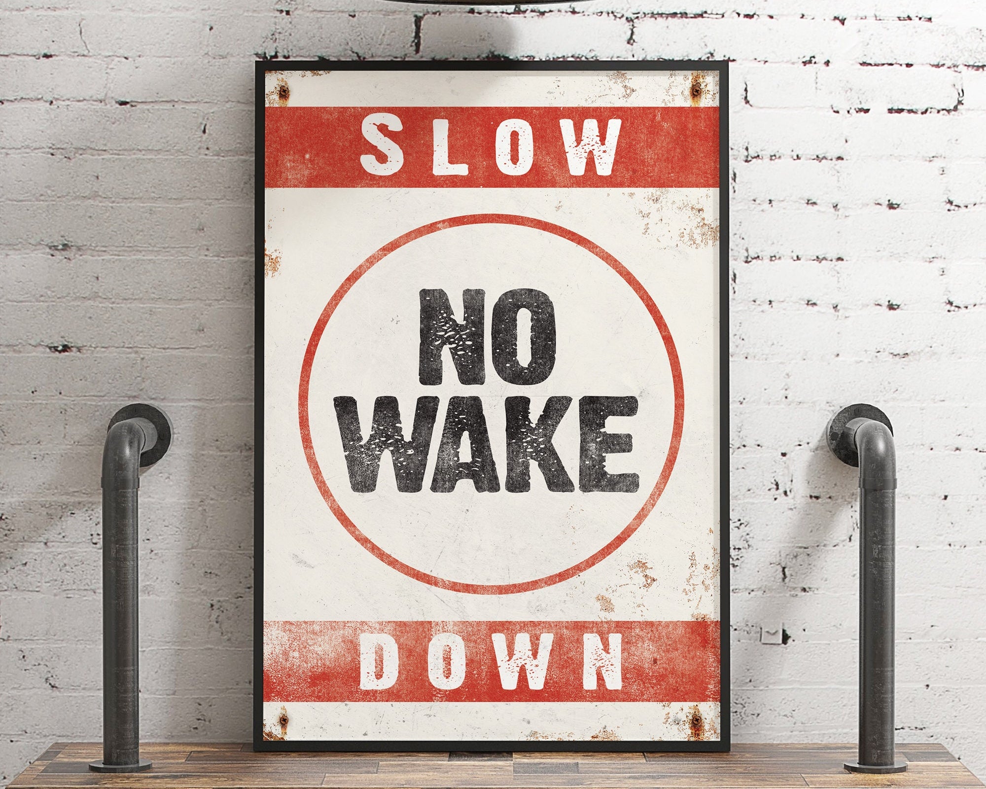 The No Wake Sign, Real Red on White, features bold text and is mounted on a shelf—ideal as unique lake house wall decor.