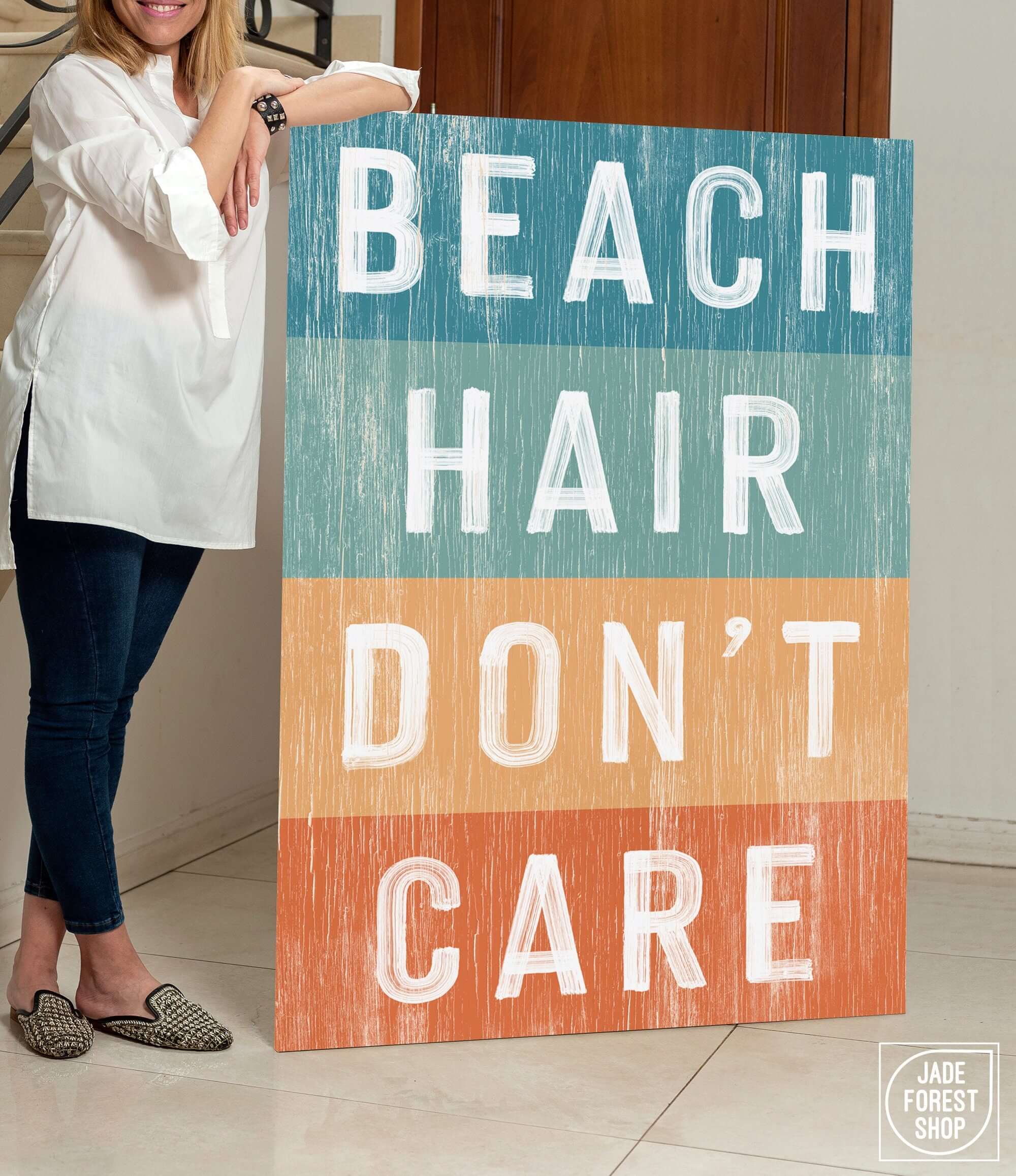 a woman standing next to a sign that says beach hair don't care