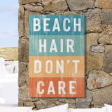 a sign that says beach hair don't care on a stone wall