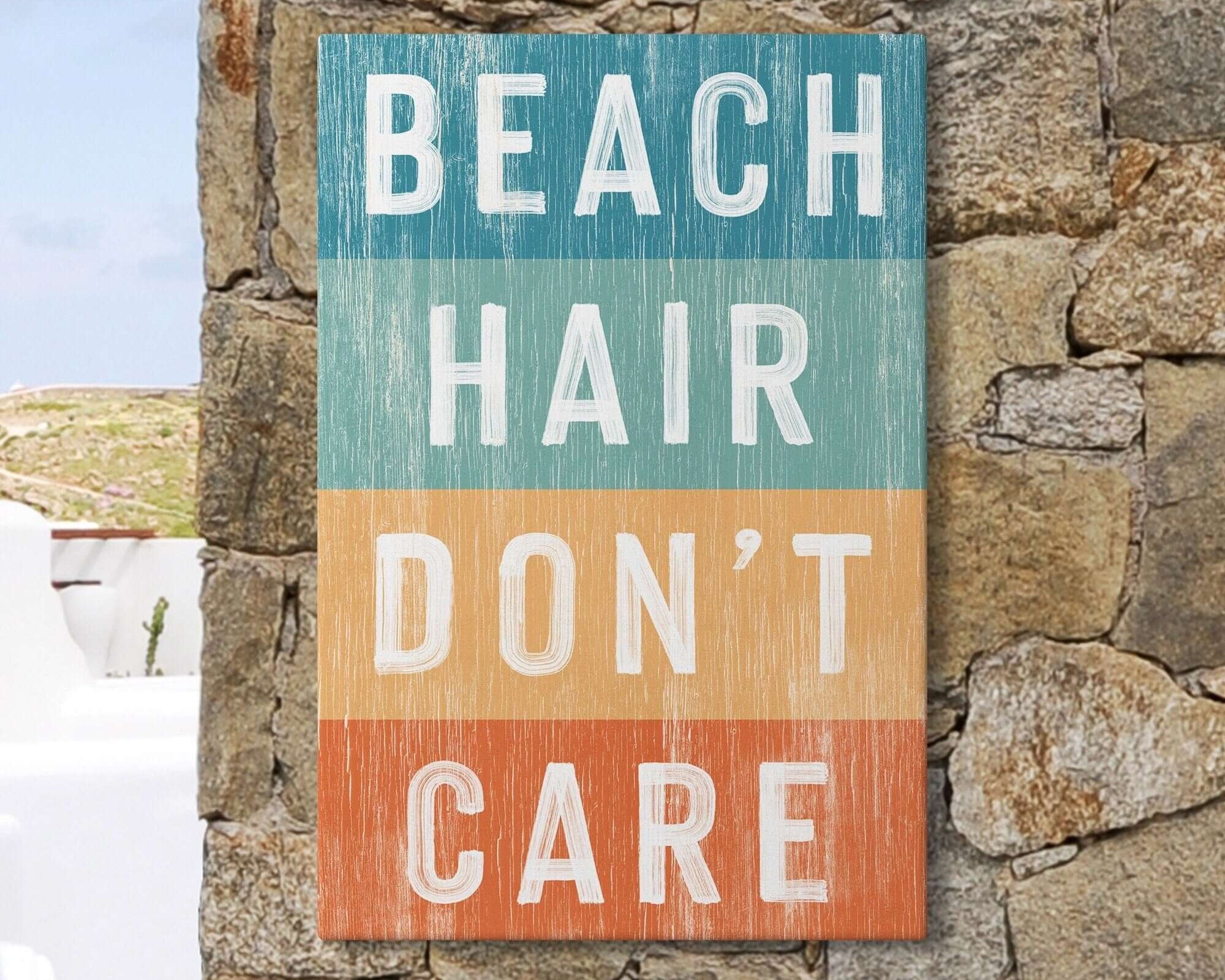 a sign that says beach hair don't care on a stone wall