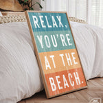 a wooden sign that says relax, you're at the beach
