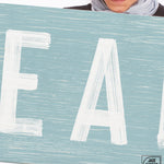 a woman holding a sign that says eat