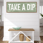 a wooden sign that says take a dip on a wall