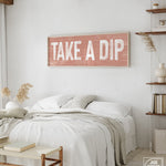 a bedroom with a bed and a wooden sign on the wall