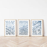 three framed art prints of blue corals against a white wall