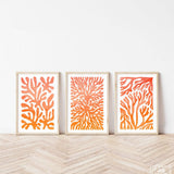 three orange and white paintings on a wall