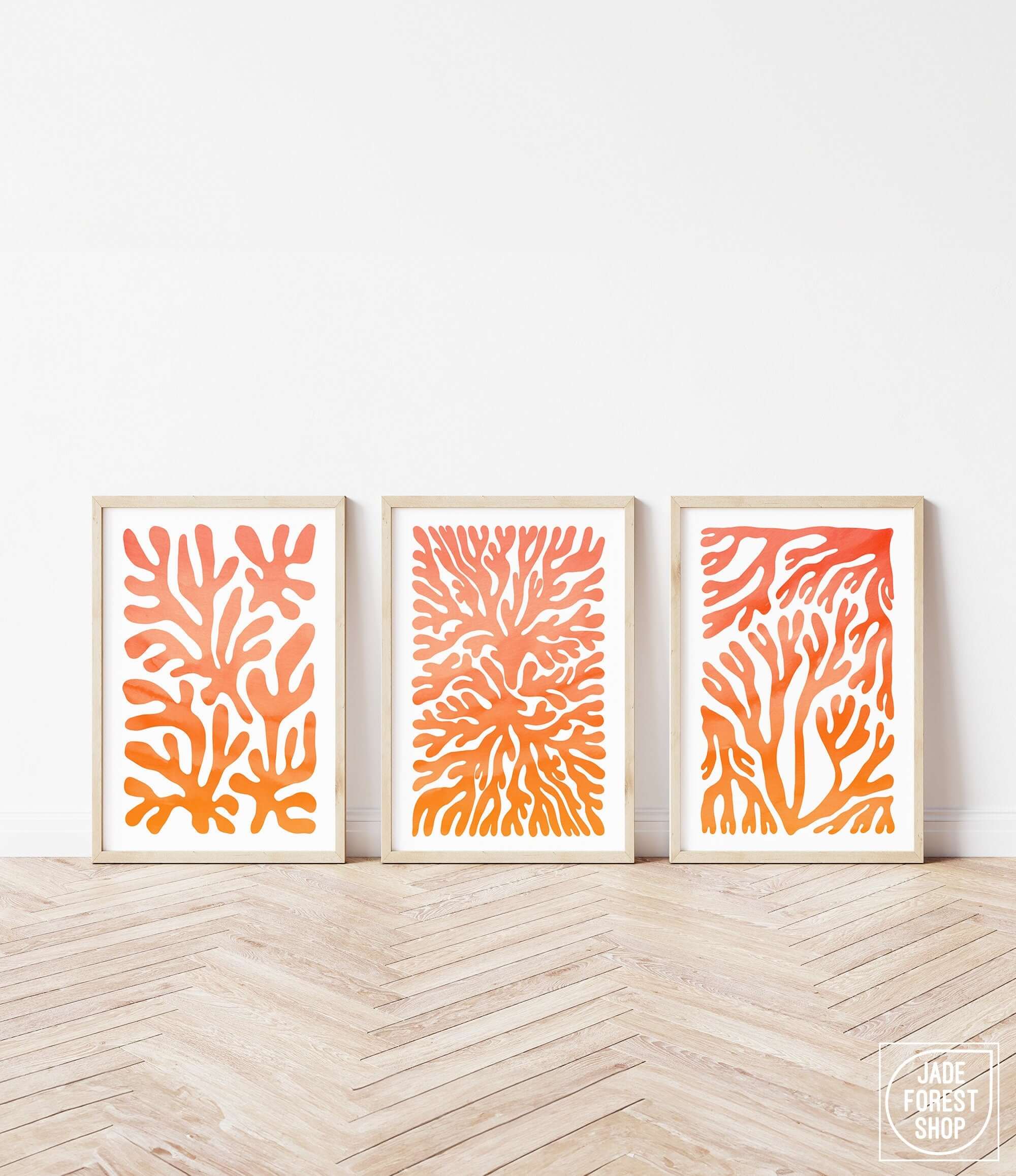 three orange and white paintings on a wall