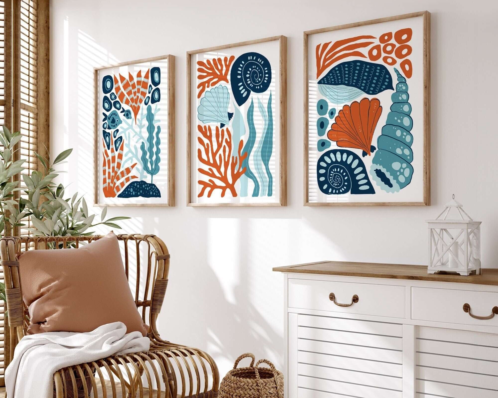 The "Ocean Blocks Triptych | Set of Three Prints | 339" adds a modern touch to your home decor, creating a striking focal point above a white cabinet in a sunlit, cozy living room.