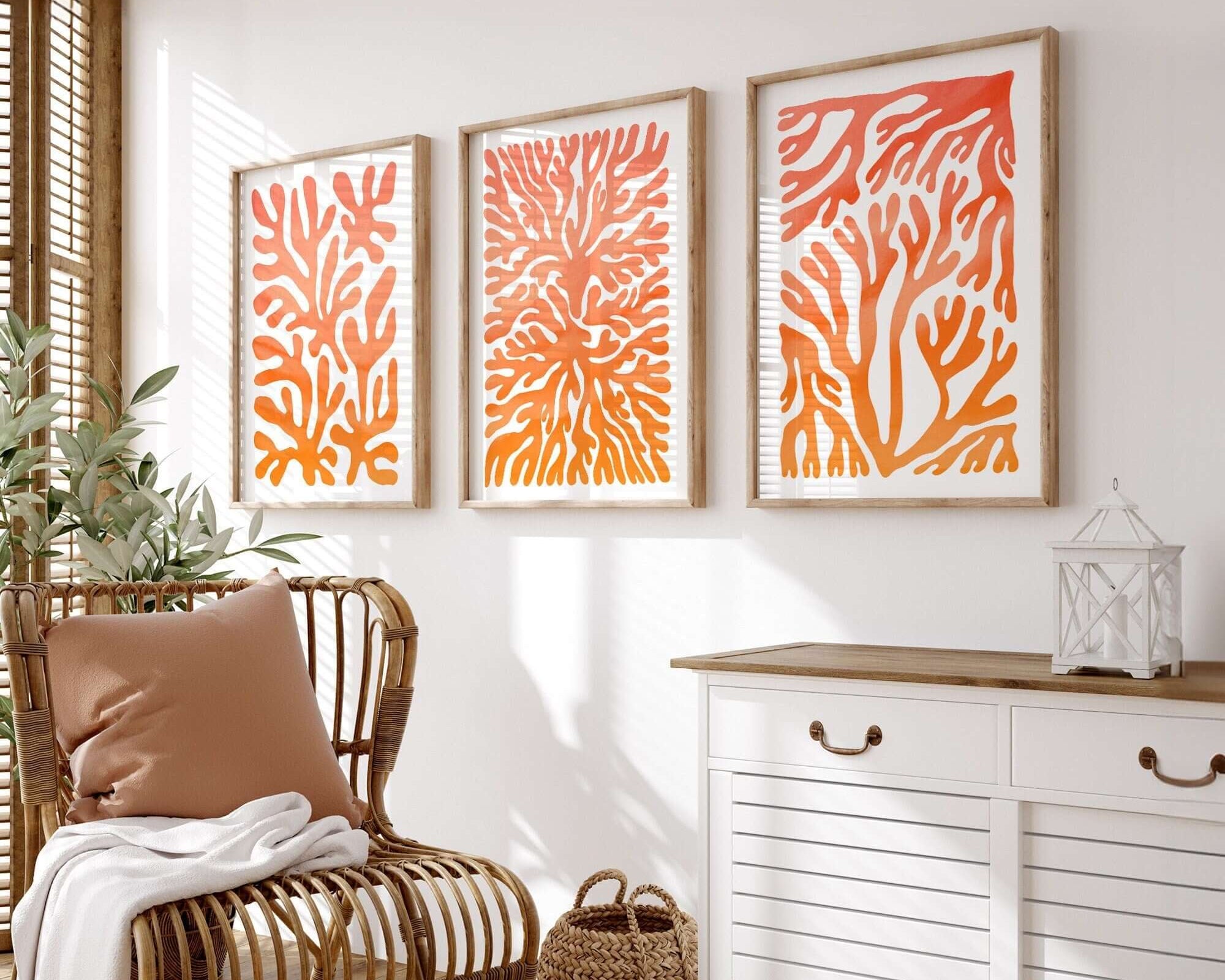 The Ocean Blocks Triptych | Set of Three Prints | 321, with coral-inspired orange designs, forms a striking wall display above your wicker chair and white cabinet, adding vibrant style to your home décor.