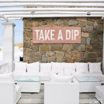 a white couch sitting under a wooden sign on a stone wall