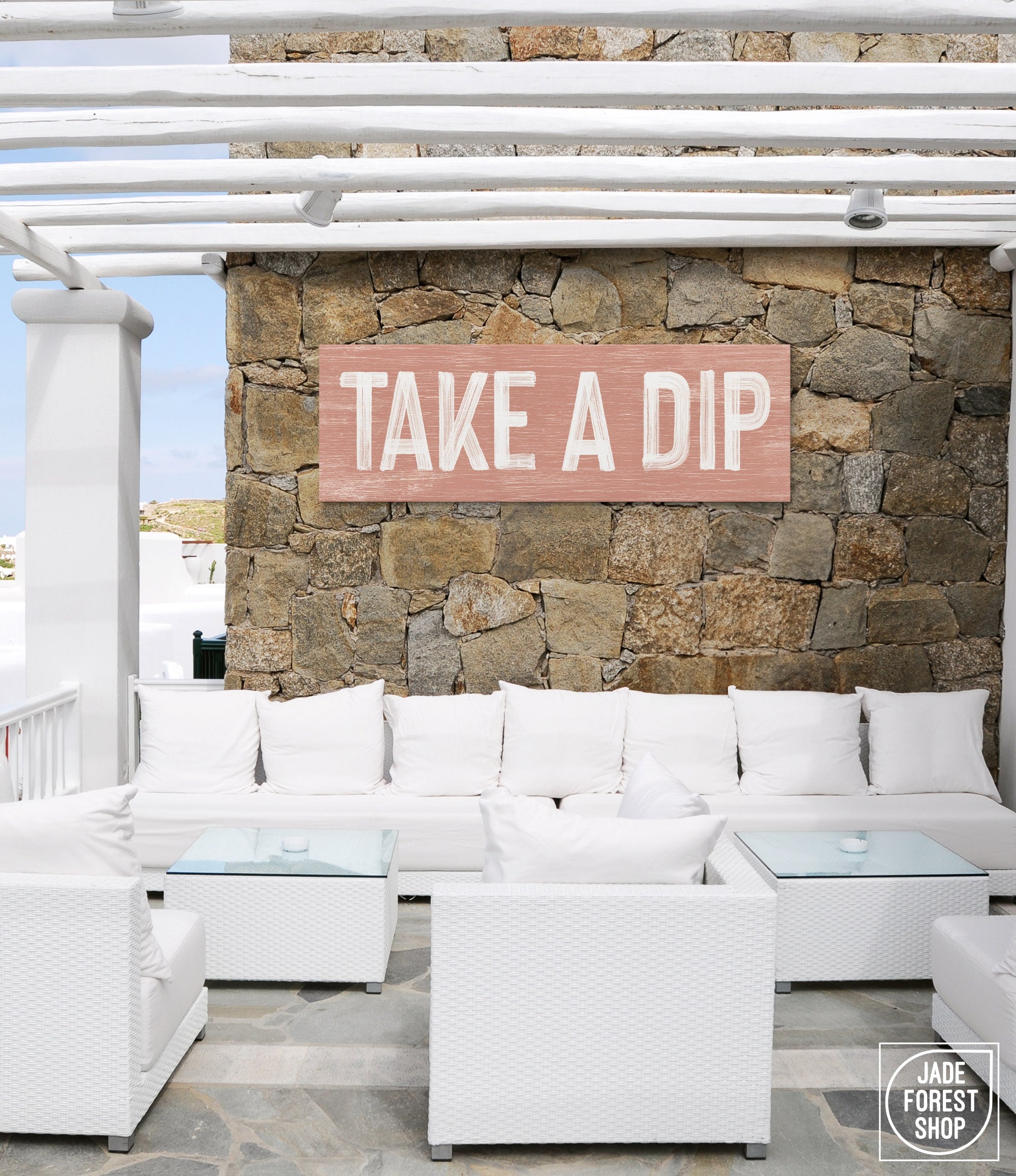 a white couch sitting under a wooden sign on a stone wall