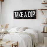 a bedroom with a bed and a wooden sign on the wall