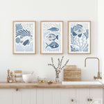 a kitchen with three framed pictures on the wall