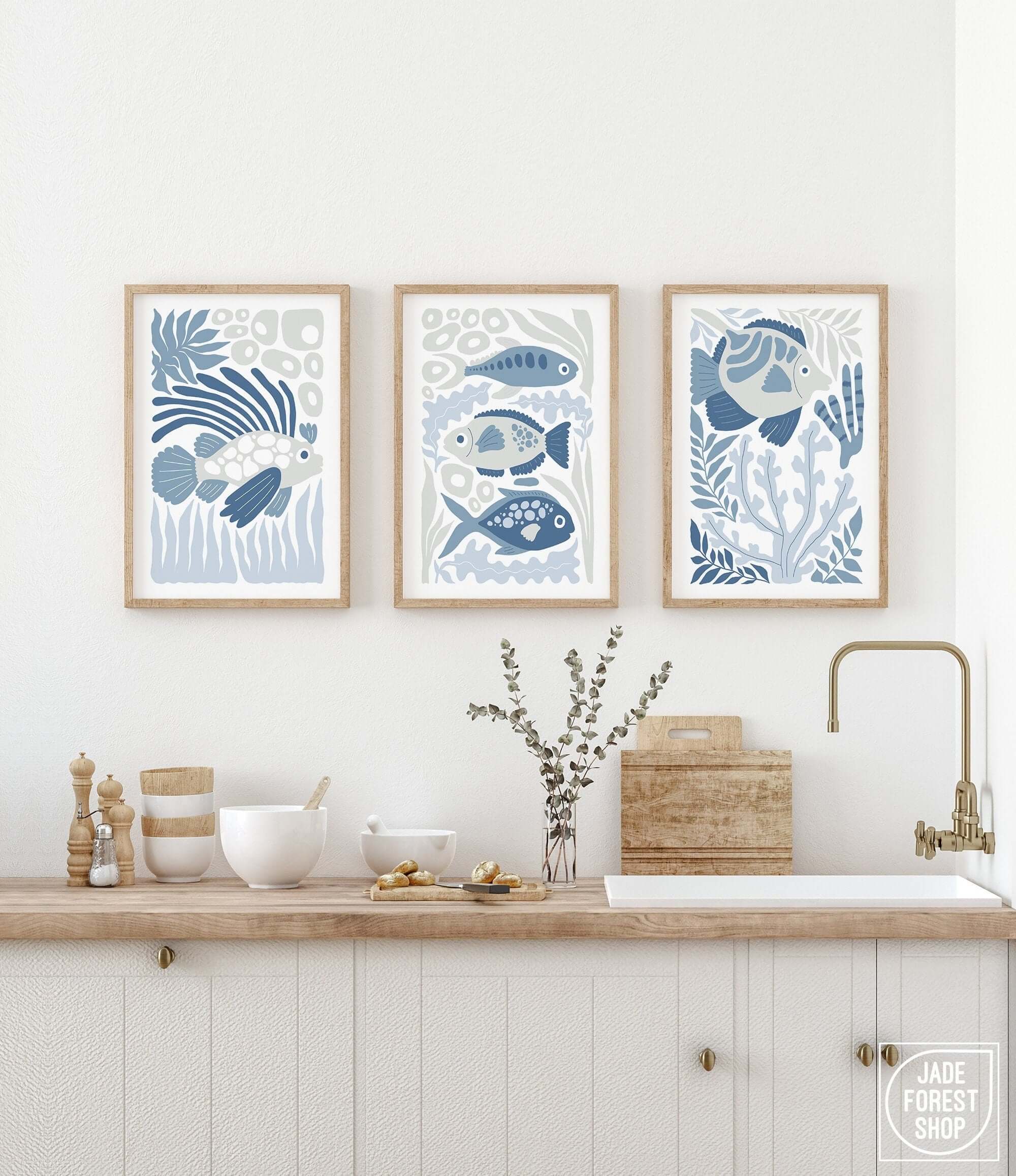 a kitchen with three framed pictures on the wall