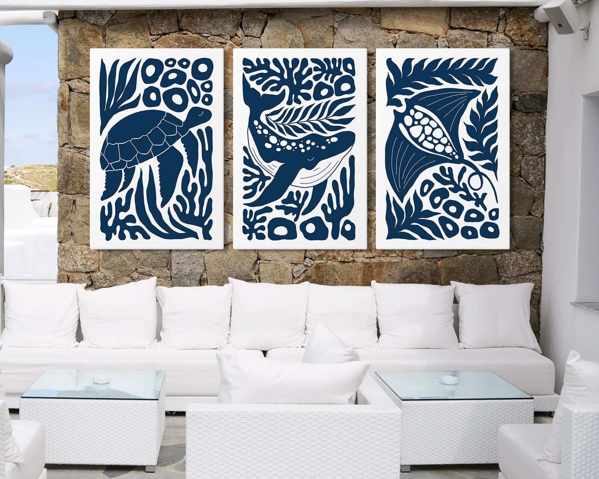 White patio with stone wall, showcasing the Ocean Blocks Triptych | Set of Three Prints | 314—blue animal-themed art—paired with white couches and tables, ideal for elegant home decor.