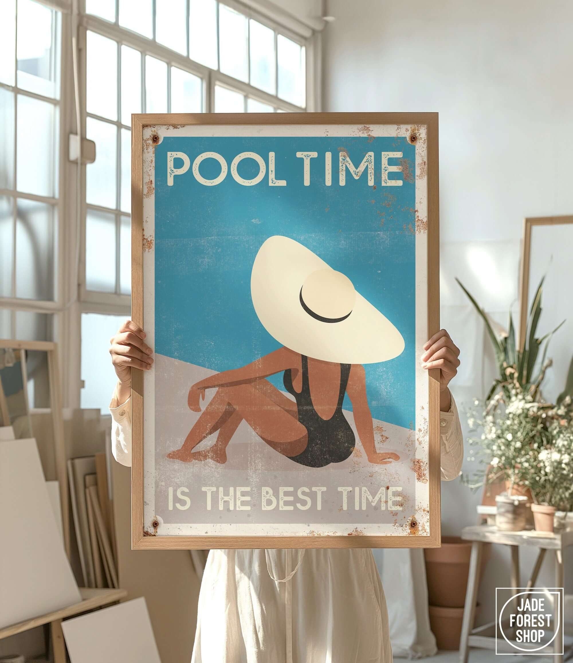 a woman holding up a poster with a picture of a woman in a bathing suit