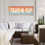 Take a dip sign with sunset background above an outdoor couch patio