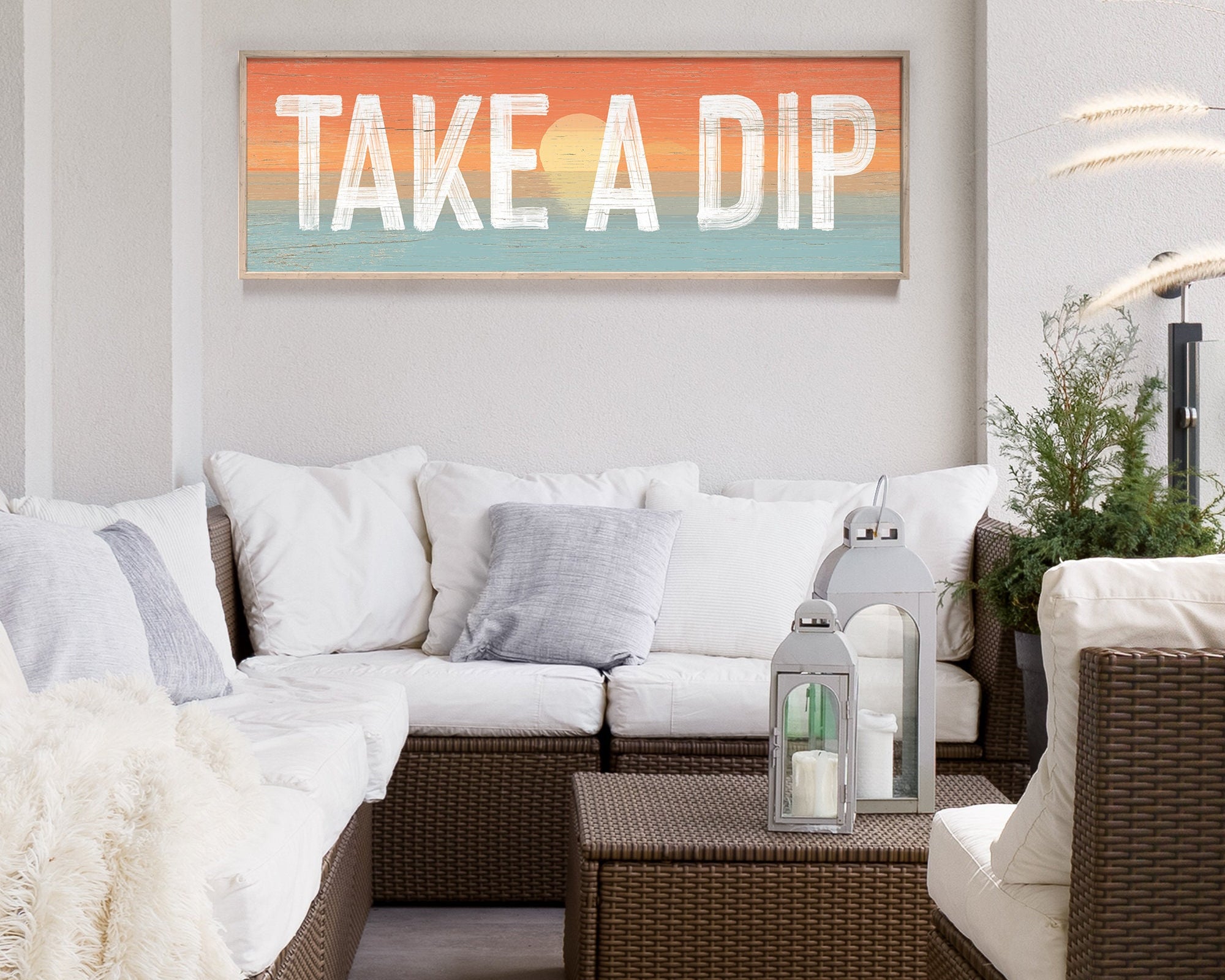 Take a dip sign with sunset background above an outdoor couch patio