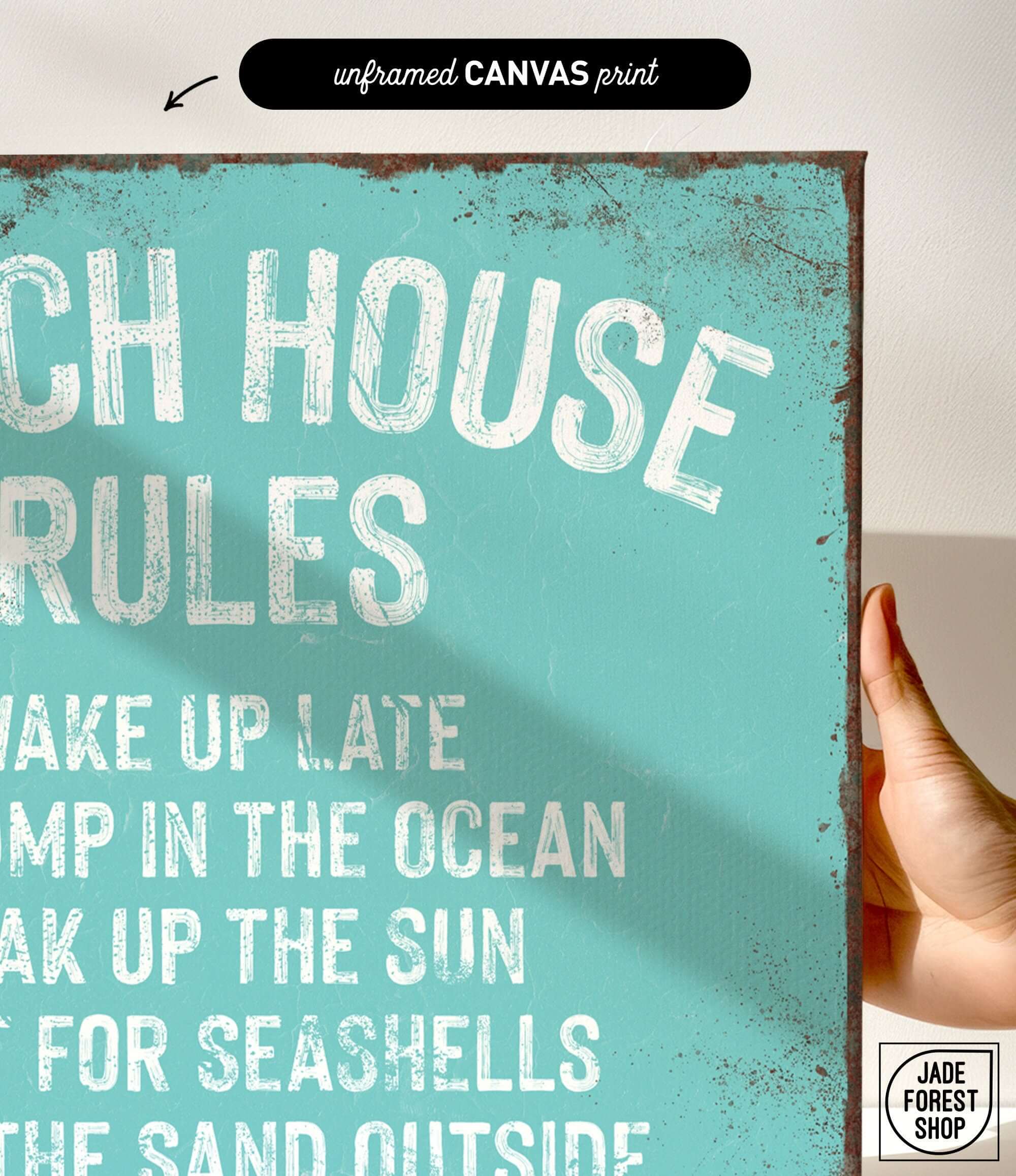 a hand holding a sign that says beach house rules