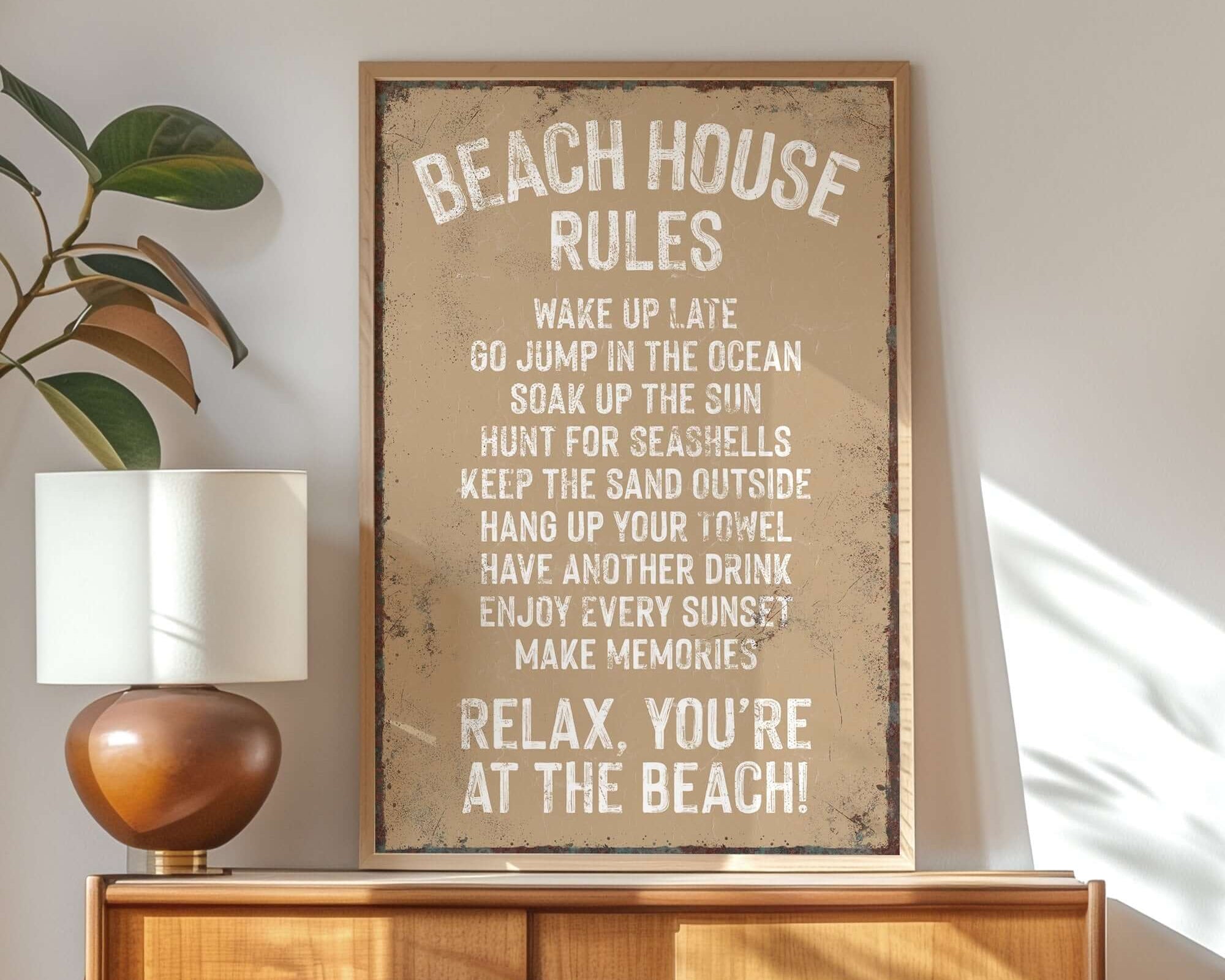 The Beach House Rules Sign, Rusted Edge, Latte brings playful charm as home wall decor, displayed atop a wooden dresser in a sunlit room with plants and a lamp.