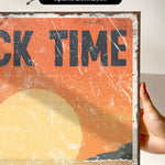 a person holding up a sign that says rock time