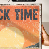 a person holding up a sign that says rock time