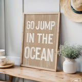 a wooden sign that says go jump in the ocean