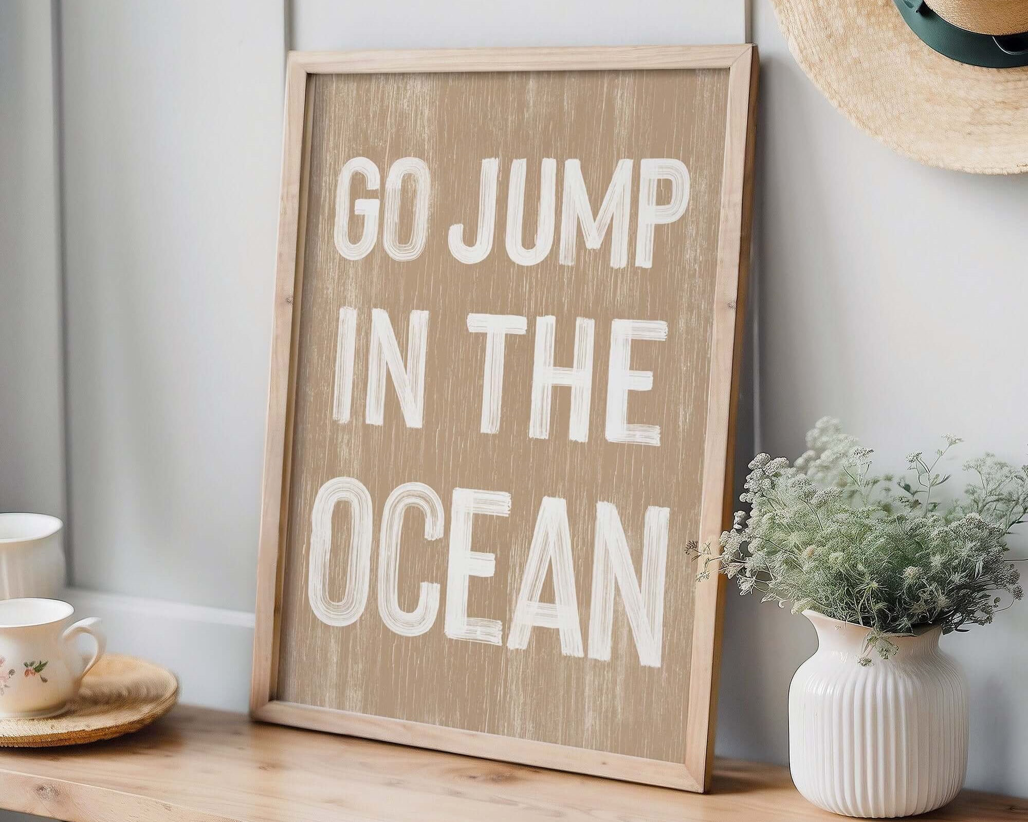 a wooden sign that says go jump in the ocean