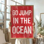 a woman holding a sign that says go jump in the ocean