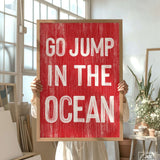 a woman holding a sign that says go jump in the ocean