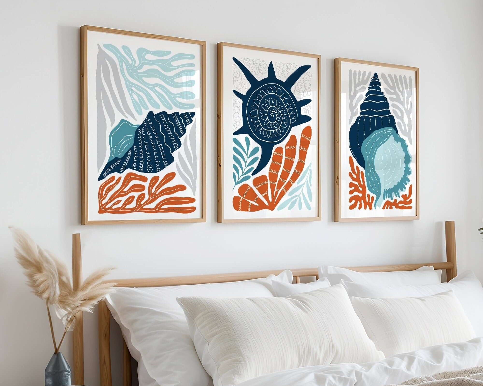 The Ocean Blocks Triptych | Set of Three Prints | 328 creates a striking focal point above a bed with white bedding and pillows, adding a stylish, coastal-inspired touch to your home decor.