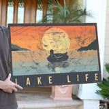 a man holding a sign that says lake life