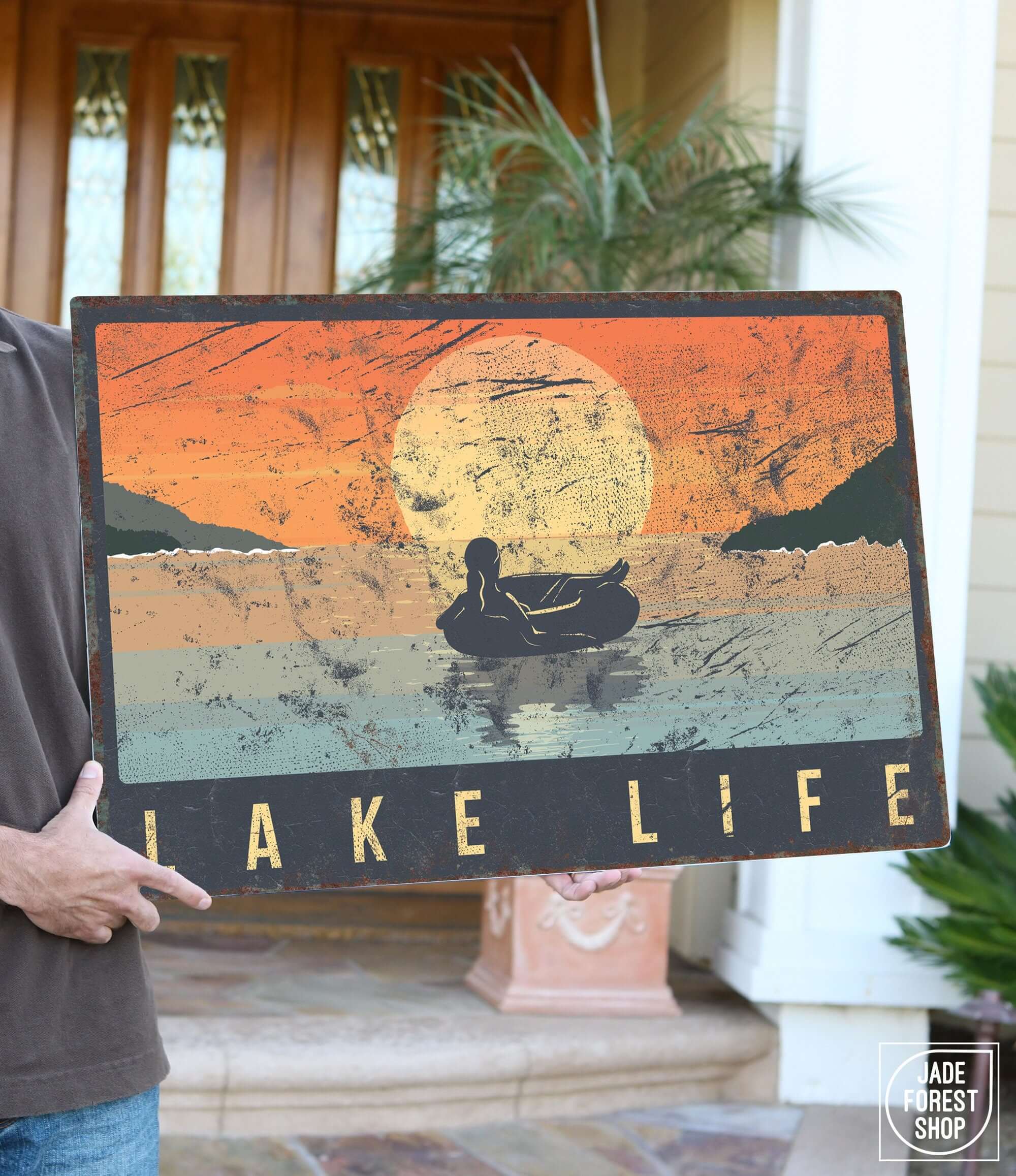 a man holding a sign that says lake life