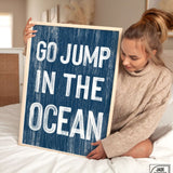 a woman holding a sign that says go jump in the ocean