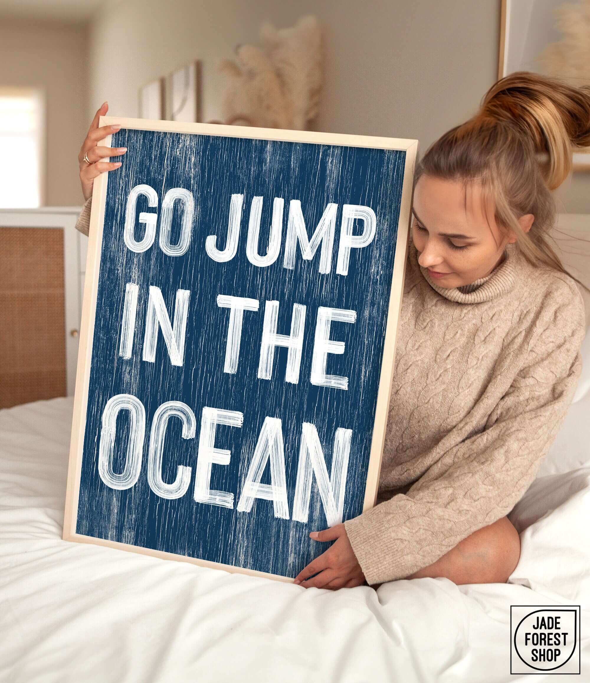 a woman holding a sign that says go jump in the ocean