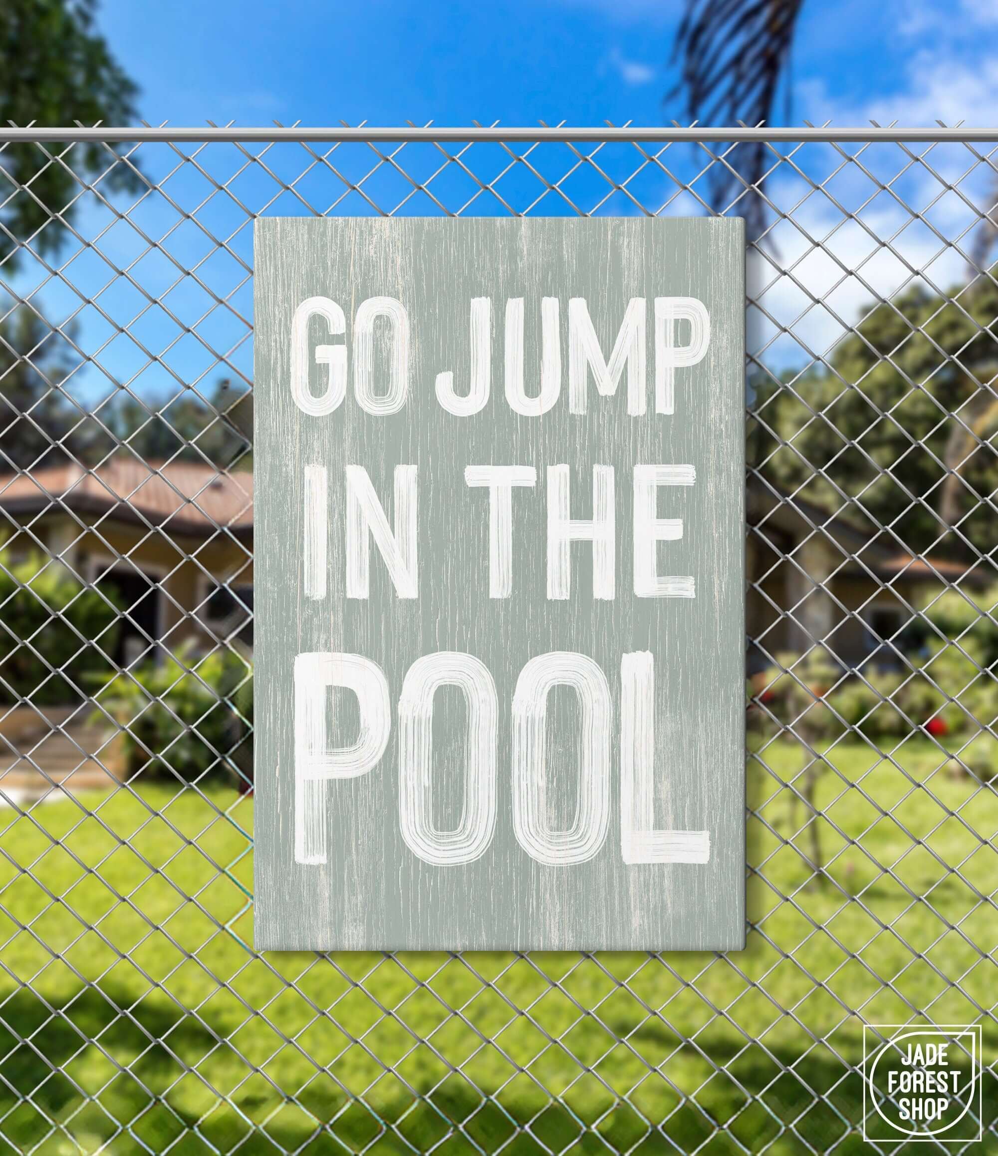 a sign that says go jump in the pool on a chain link fence