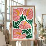 a woman holding up a painting of pink flowers