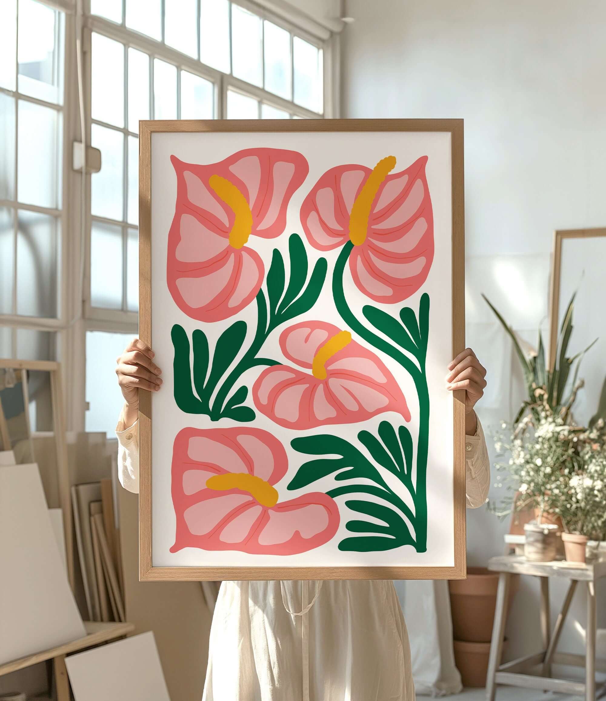 a woman holding up a painting of pink flowers