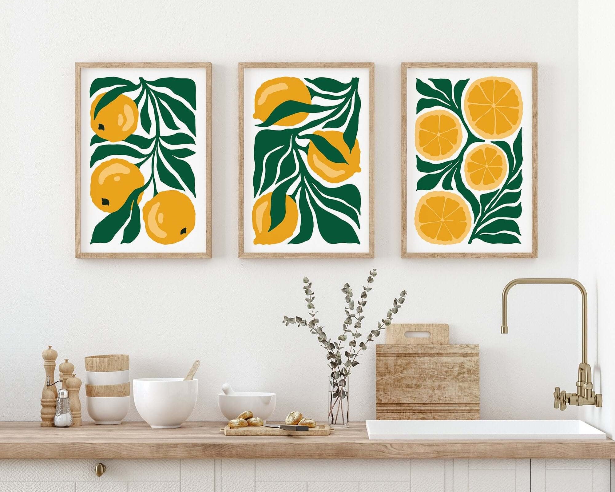 The "Tropical Blocks Triptych | Set of Three Prints | 425" hangs above a minimal kitchen counter with dishes and decor, bringing fresh, vibrant style to your home.
